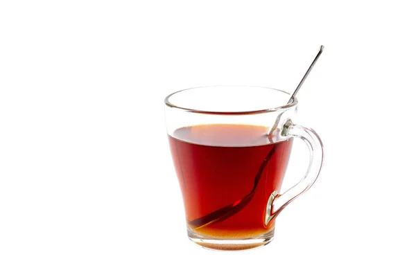 Bir fincan çay ve içinde bir kaşık beyaz izole bir arka plan.