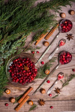 Noel için malzemeler, kış kurabiyeleri. Zencefilli çörek, meyveli kek, mevsimlik içecekler. Kızılcıklar, kurutulmuş portakallar, tarçın, ahşap masadaki baharatlar, uzay manzarasını kopyala.