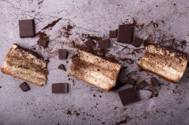 Geleneksel İtalyan tatlı tiramisusu. Masadaki bazı parçalar dağınık ve çikolatalı. en üstteki görünüm