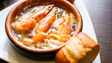 Geleneksel İspanyol mutfağı Ajillo karides ve sarımsak ile ahşap bir kasede taze pişmiş ekmekle servis edilir..