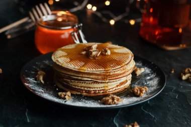 Dutch waffles with honey and nuts. Romantic composition with candles and other elements