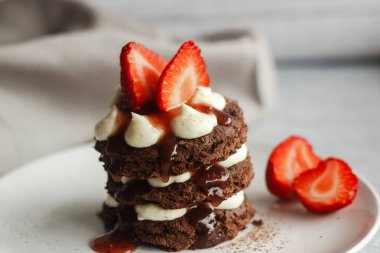 Kremalı ve çilekli lezzetli bir pasta. Çikolatalı kek, krem peynir ve ahududu dolgulu. Üstünde çilek süslemesi.