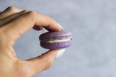 Kurabiyeler. Lezzetli Fransız tatlıları. Makaronlar bir elde