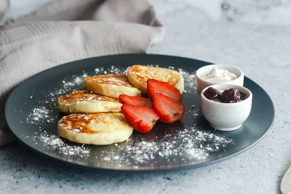 イチゴとおいしいチーズパンケーキ サワークリームとチェリージャム プレート上のチーズパンケーキ — ストック写真