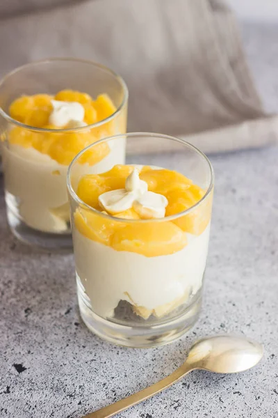 Tasty lemon dessert in a glass. Lemon dessert with biscuit, white chocolate and lemon curd