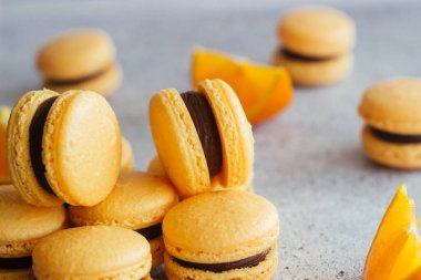 Kurabiyeler. Lezzetli Fransız tatlıları. Çikolatalı ve portakallı kurabiye. Makarnalar masaya.