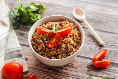 Domatesli ve otlu karabuğday. Geleneksel Rus yemekleri. Köy tarzı. Tabak ahşap masada.