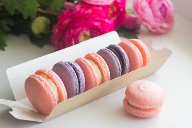 Kurabiyeler. Lezzetli Fransız tatlıları. Krem peynirli ve çikolatalı makarna. Makarnalar masaya.