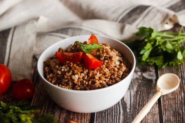 Domatesli ve otlu karabuğday. Geleneksel Rus yemekleri. Köy tarzı. Tabak ahşap masada.