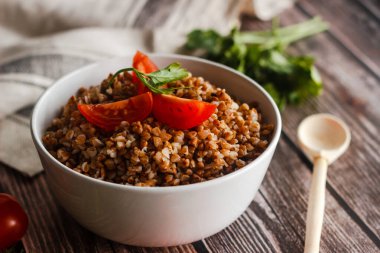 Domatesli ve otlu karabuğday. Geleneksel Rus yemekleri. Köy tarzı. Tabak ahşap masada.
