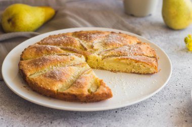 Lezzetli armut ve bademli turta. Çiçekli romantik bir yaz kompozisyonu. Tabakta turta
