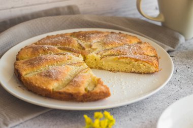 Lezzetli armut ve bademli turta. Çiçekli romantik bir yaz kompozisyonu. Tabakta turta