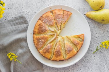 Lezzetli armut ve bademli turta. Çiçekli romantik bir yaz kompozisyonu. Tabakta turta