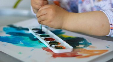 Çocuk boyalar ile boyar. Suluboya ile çocuk çizim.