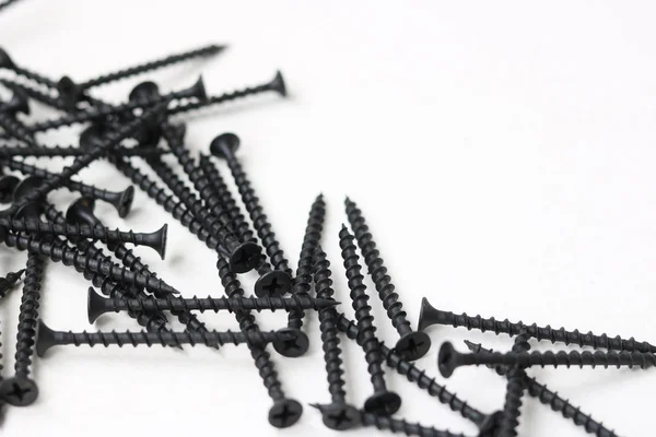 beyaz zemin üzerine siyah vidalar