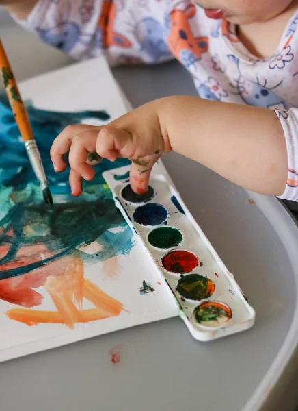 Çocuk boyalar ile boyar. Suluboya ile çocuk çizim.