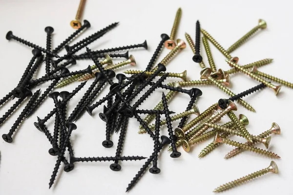 Beyaz bir arka planda sarı ve siyah vidalar