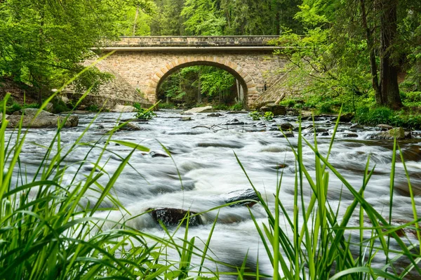 View of the stone bridge Zemska brana and a mountain river in the woods