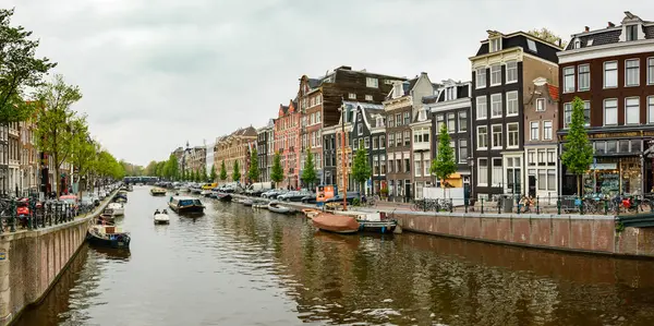 En klassisk vattenkanal i Amsterdam, utsikt från bron över de nederländska stadsbyggnaderna. — Stockfoto