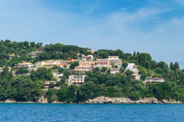 Dağ yamacına evler inşa edildi. Sahildeki ağaçların arasına..