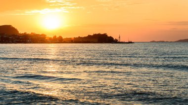 Korfu, uzak diyarlarda denizin üzerinde renkli bir günbatımı..