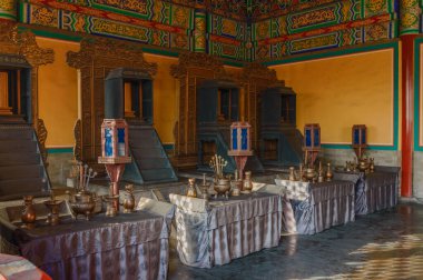 Cennetin Tapınağı 'nda zengin dekore edilmiş bir salon. Tabakları ve renkli duvarları olan bir masa..