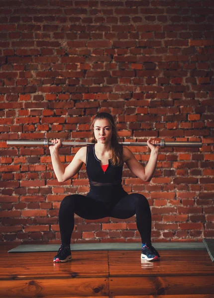 woman squats with barbell