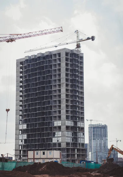 construction of a concrete house, construction is underway, cranes are working