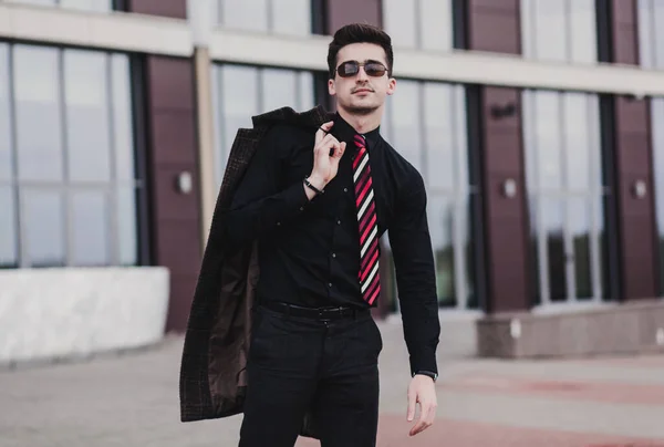 Elegant young businessman in formal style. Black shirt and pants