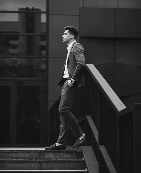 Portrait of a trendy man in full suit and loafers. Looking away