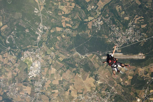 Тандемний стрибок парашутом над садом — стокове фото