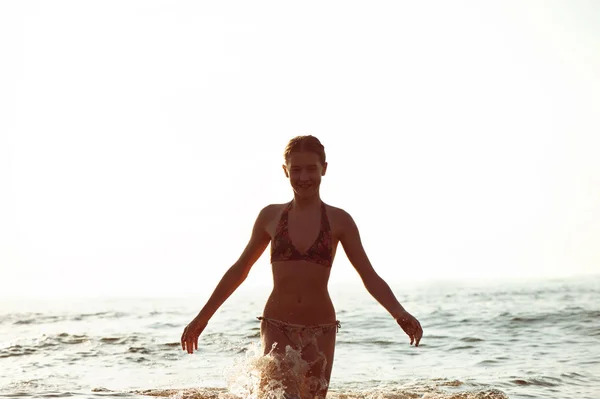 Silhouette of girl having fun in Baltic sea splashing waves — Stock Photo, Image