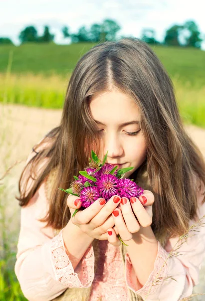 Doğanın güzelliği. Genç kız çayır yonca akışı kokulu gülümseyen — Stok fotoğraf
