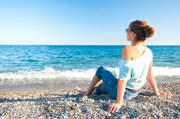 Jeune belle adolescente assise sur le galet de la mer Méditerranée — Photo