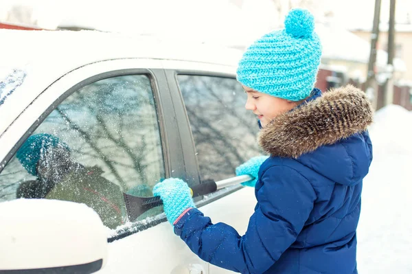 Fiatal tizenéves lány kaparás jég, a kocsi ablakon a téli hó — Stock Fotó