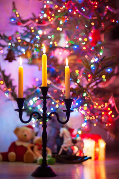 Portavelas con llama encendida en árbol de navidad iluminado b — Foto de Stock