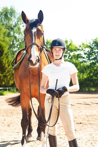 Jovem adolescente equestre de pé com seu cavalo marrom — Fotografia de Stock