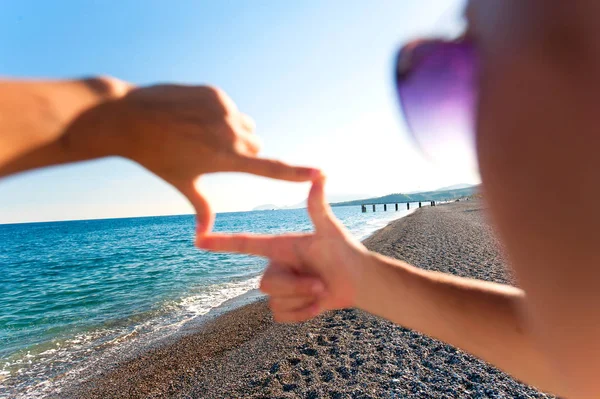 Композиція палець рамка- руки дівчини захоплюють вражаючий морський пейзаж — стокове фото