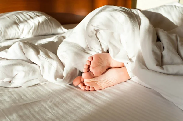 Sov lilla barn roliga söta fötter i tidig morgon sunbeam — Stockfoto