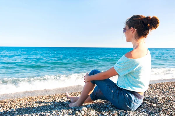 Jeune belle adolescente assise sur le galet de la mer Méditerranée — Photo