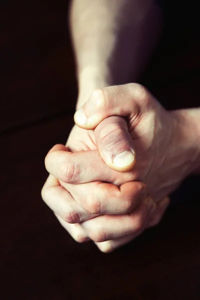 男の強い手を握り締めて暗い木製のテーブルの上. — ストック写真