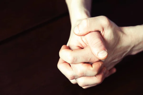 男の強い手を握り締めて暗い木製のテーブルの上 — ストック写真