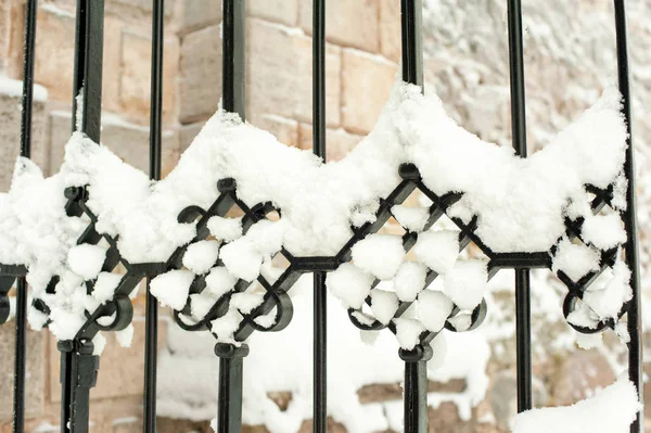 Fém díszítő fekete kerítés görbék hóval. — Stock Fotó