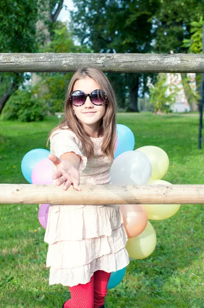 Come along to a party! Girl with multicolored balloons bunch