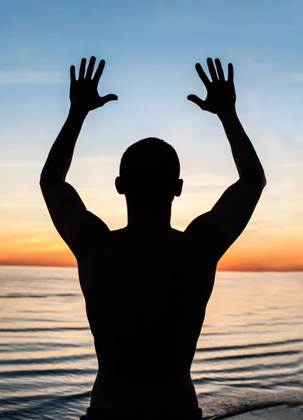 Conocer el amanecer. Silueta de hombre en rayos de luz solar . — Foto de Stock