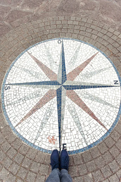 In which way? Mosaic compass rose background and woman sneakers.