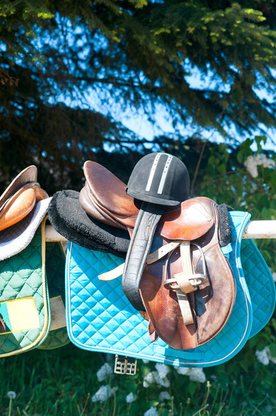 Equestrian sport equipment and accessories hanging on fence