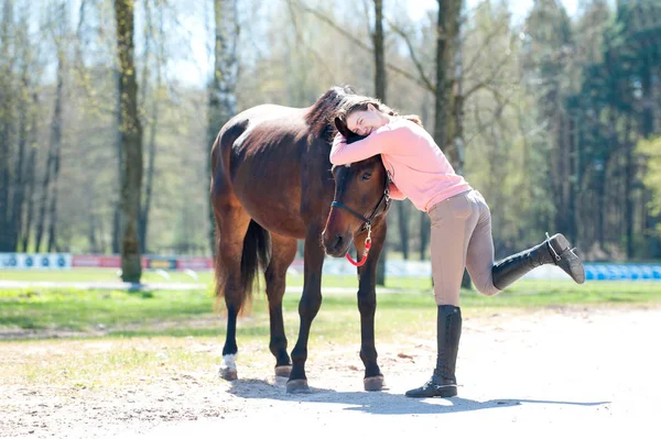 Joven alegre adolescente propietario abrazando a su caballo favorito — Foto de Stock