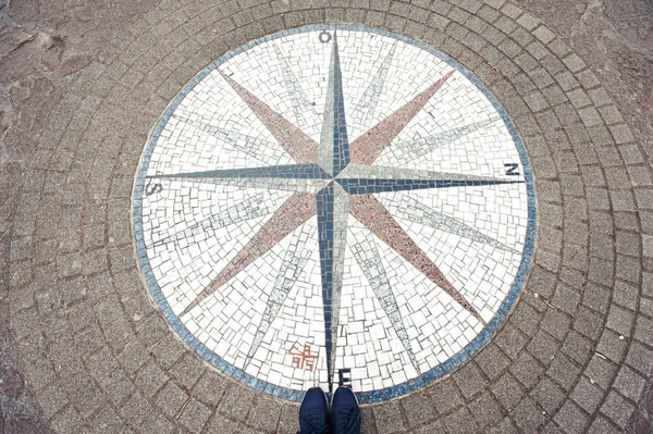 In which way? Mosaic compass rose background and woman sneakers. — Stock Photo, Image