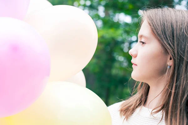 Docela s úsměvem mladá dospívající dívka s různobarevné balónky buchta — Stock fotografie